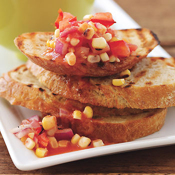 slices of toasted baguette topped with tomato corn bruschetta