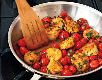 scallops, cherry tomatoes and parsley in a sauté pan