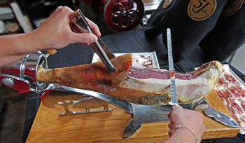 slicing from a whole spanish ham on a holder