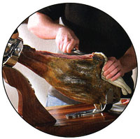 slicing a bone-in ham in a ham holder